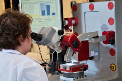 Engineer looking at a component under a microscope