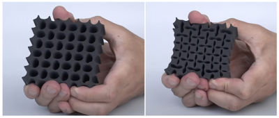 A hand squishing a squared structure filled with holes
