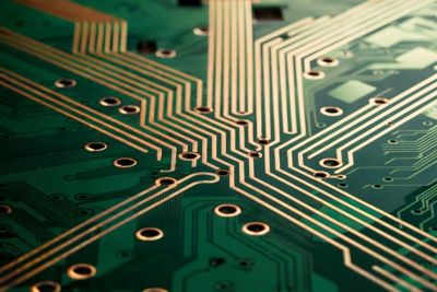 Close-up View of Green Printed Circuit Board with Copper Traces and Via Holes