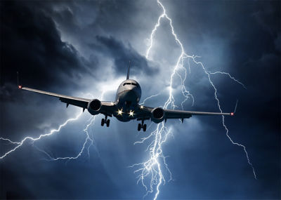 Passenger airplane travelling through sky against stormy bolt cloudscape