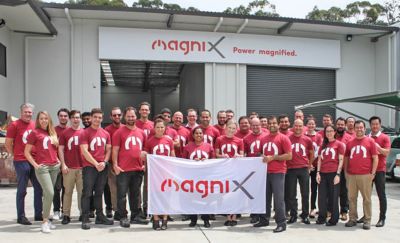 MagniX team holding up banner