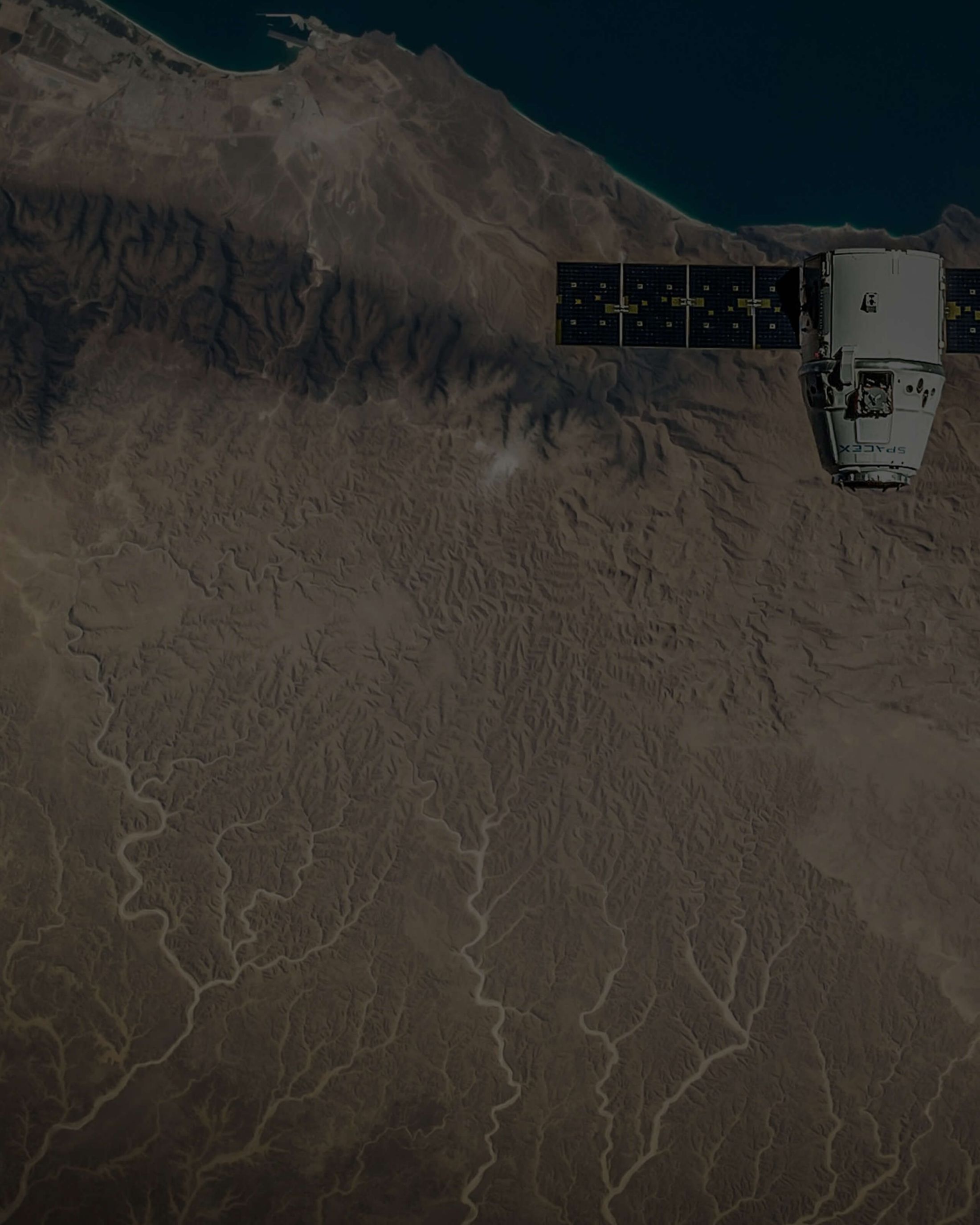 Background image of satellite orbiting over desert landscape